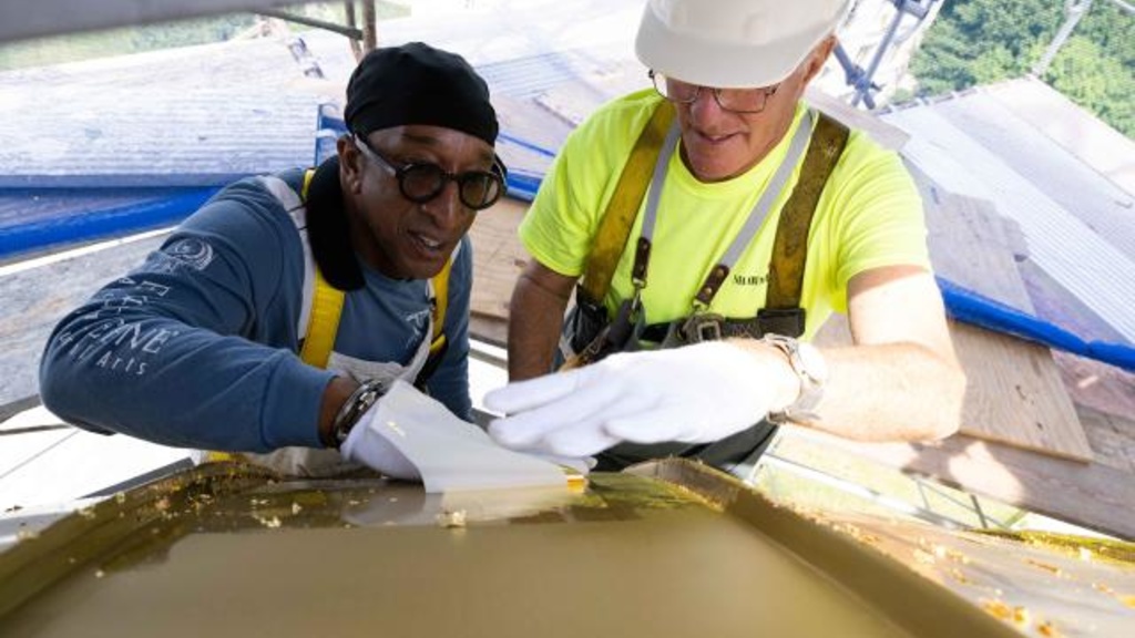 Workers replace the gold leaf on the Old Capitol Dome in summer 2022